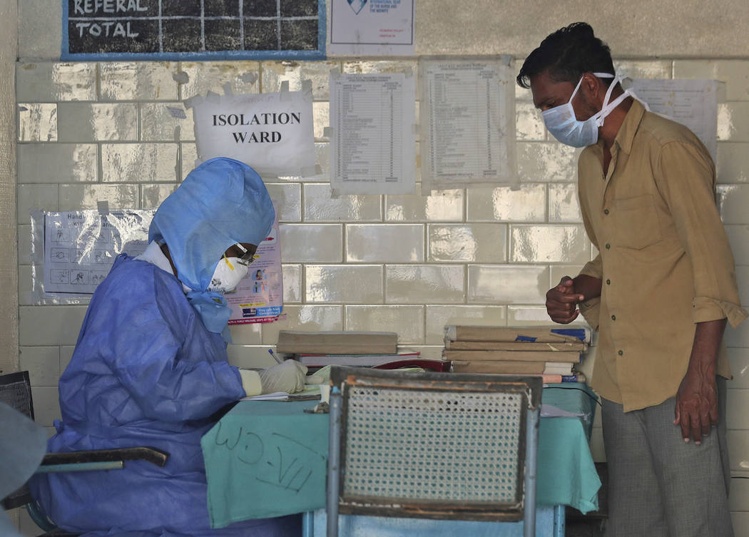In this Sunday, March 15, 2020, photo, an Indian doctor in a protective suit sits outside an is ...