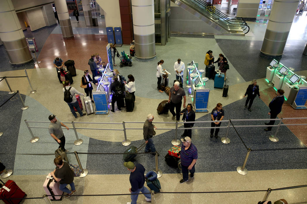 Passengers check in for flights at American Airlines at McCarran International Airport in Las V ...