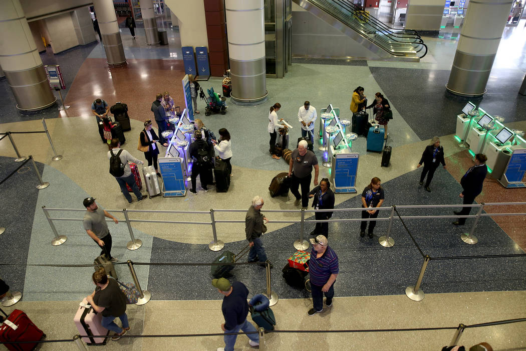 Passengers check in for flights at American Airlines at McCarran International Airport in Las V ...