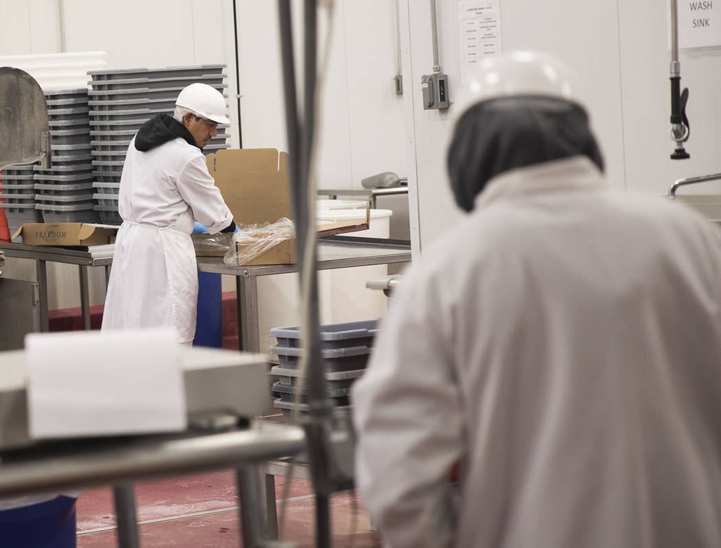Workers process meat at Blackbox Meats distribution center in Las Vegas, Sunday, March 15, 2020 ...