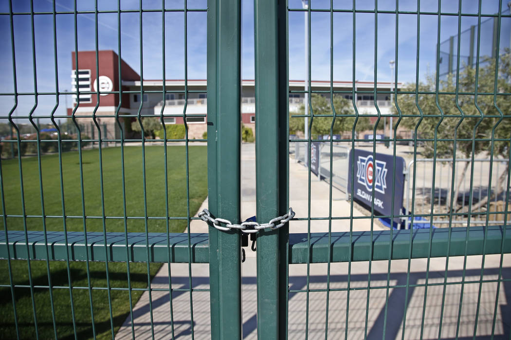 A gate at the Chicago Cubs practice facility at Sloan Park in Mesa, Ariz., is closed and locked ...