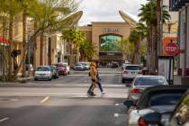 A few shoppers cross the street at Downtown Summerlin which has modified hours and some busines ...