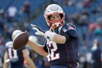 New England Patriots quarterback Tom Brady warms up before an NFL football game against the Mia ...