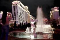 A woman takes a photo of Caesars Palace on the Las Vegas Strip, Saturday, March 14, 2020. (Elle ...