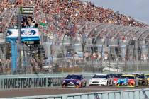 Denny Hamlin, left, leads the pack at the start of the NASCAR Cup Series championship auto race ...