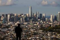 A man looks toward the skyline from Bernal Heights Hill in San Francisco, Monday, March 16, 202 ...