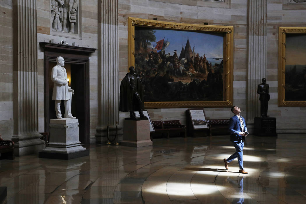 A man walks through an empty U.S. Capitol Rotunda on Capitol Hill in Washington, Monday, March ...