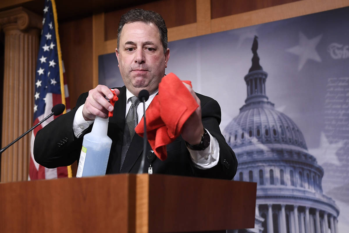 Mike Mastrian, director of the Senate Radio and Television Gallery, cleans down the podium befo ...