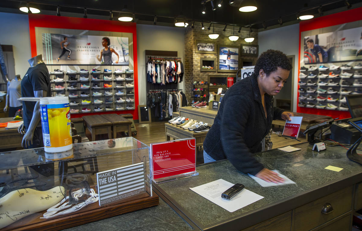 New Balance salesperson Heaven Fennell wipes down her counters and common areas at their Downto ...