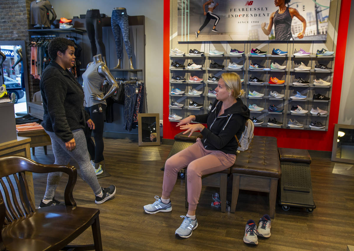 New Balance salesperson Heaven Fennell, left, works with customer Sandra Rivers at their Downto ...