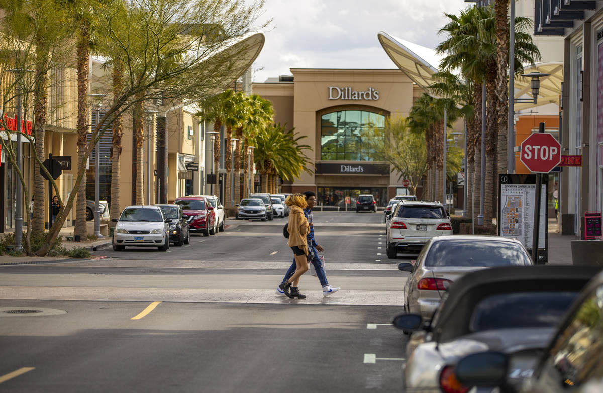 A few shoppers cross the street at Downtown Summerlin which has modified hours and some busines ...