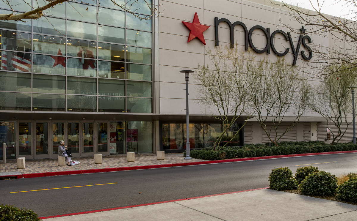 An elderly shopper sits outside of the Macy's store in Downtown Summerlin which has modified ho ...