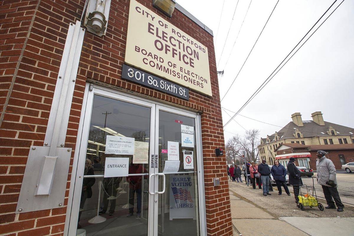 People stand in line to vote at the City of Rockford Election Office on Monday, March 16, 2020, ...
