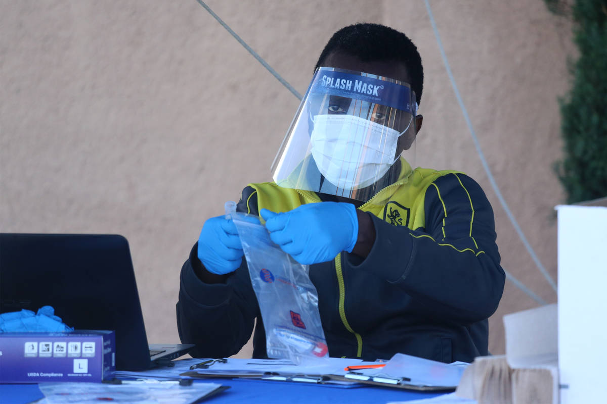 A lab technician processes a collected swab sample at the Sahara Urgent Care & Wellness center ...