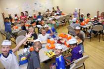 Kids enjoy a free meal sponsored by Three Square June 29, 2010, at the Summer Food Service Prog ...
