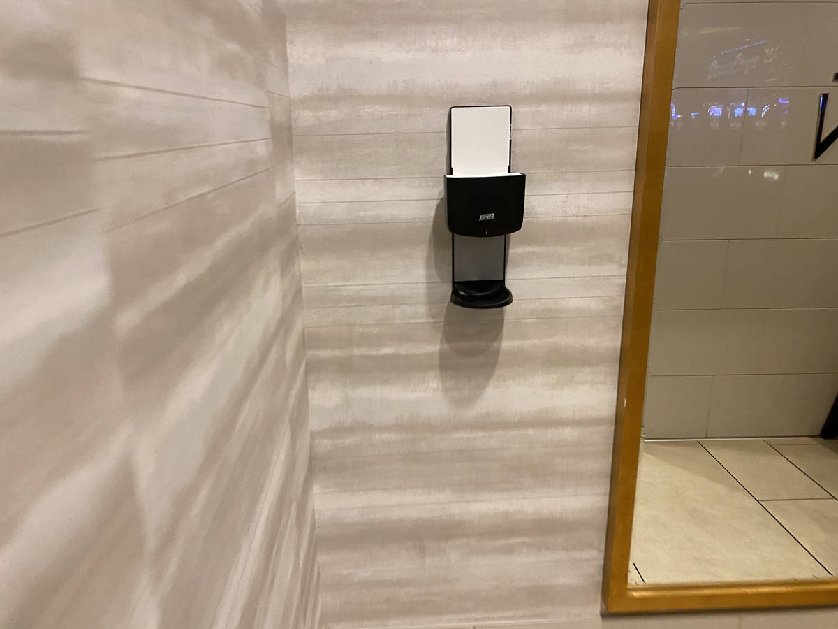 Holders that usually house hand sanitizer dispensers in several South Point restrooms sat empt ...