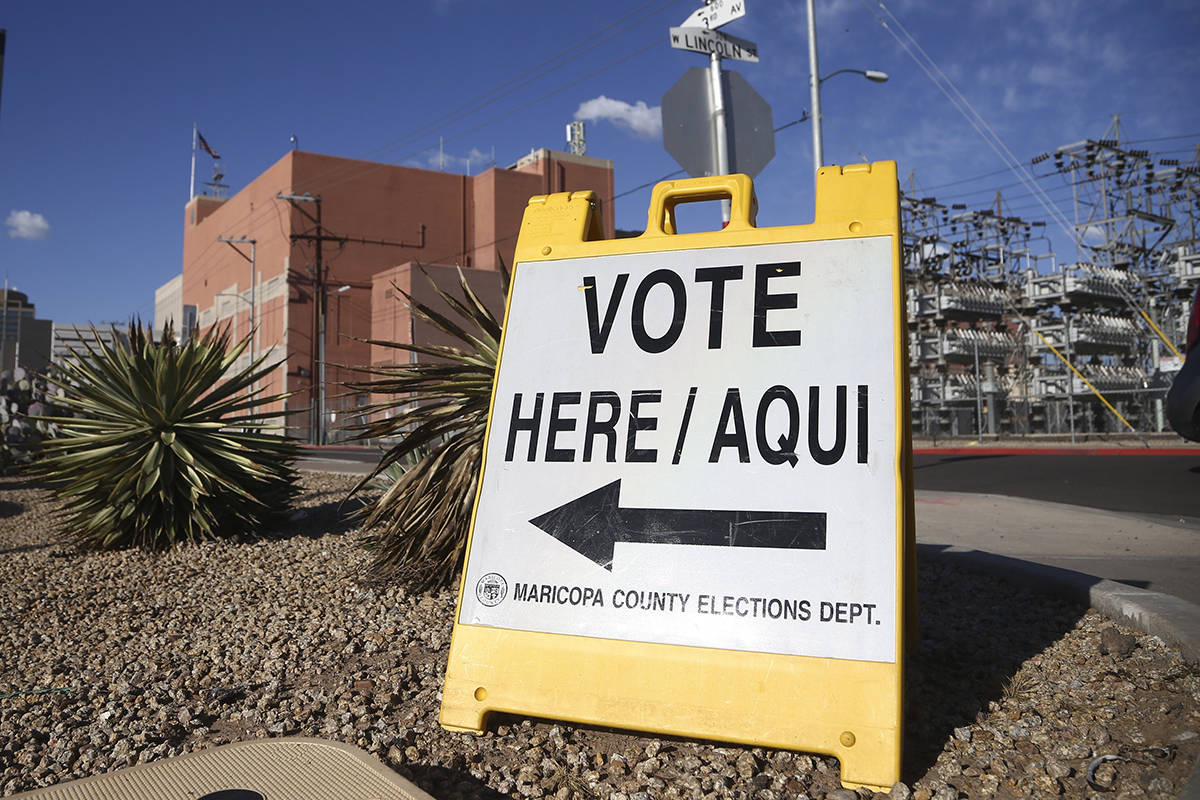A sign points to a local polling station for the Arizona Democratic presidential preference ele ...