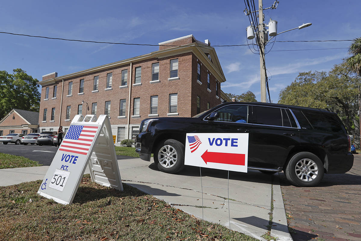 A voter enters the parking lot of a polling station to vote in Florida's primary election, Tues ...