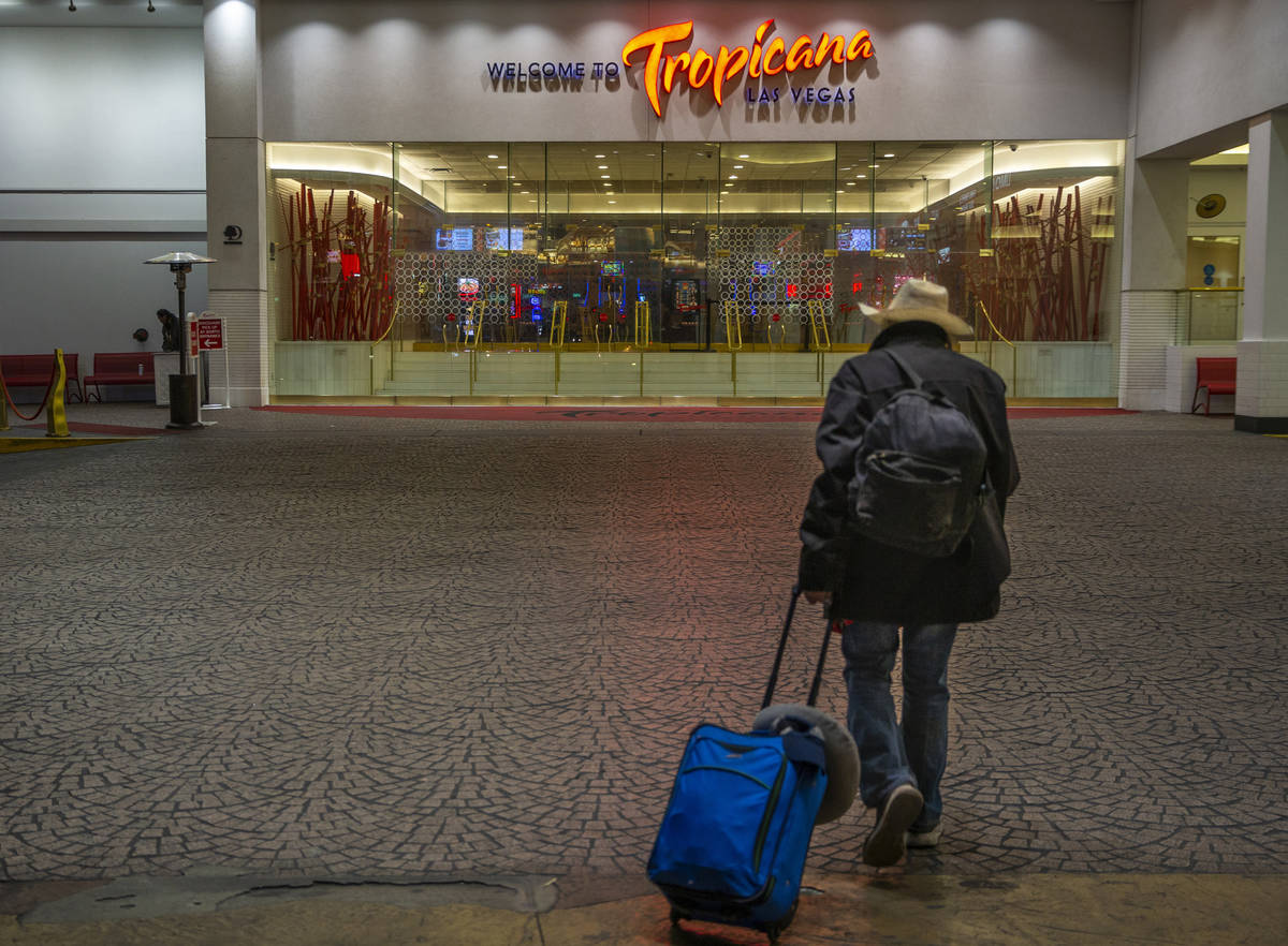 A lone traveler walks towards the entrance to the Tropicana as non-essential business closures ...