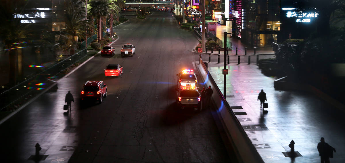 A few pedestrians walk along Las Vegas Blvd. near the MGM Grand as non-essential business closu ...