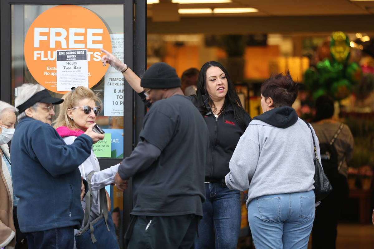 Smith's store manager Jessica Iverson assists seniors over 60 who were allowed into the grocer ...