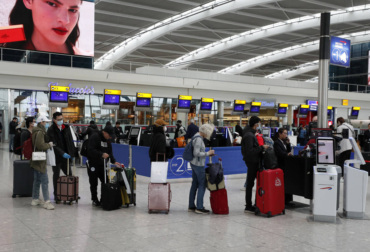 People queue at ticket machines at Heathrow airport in London, Wednesday, March 18, 2020. For m ...