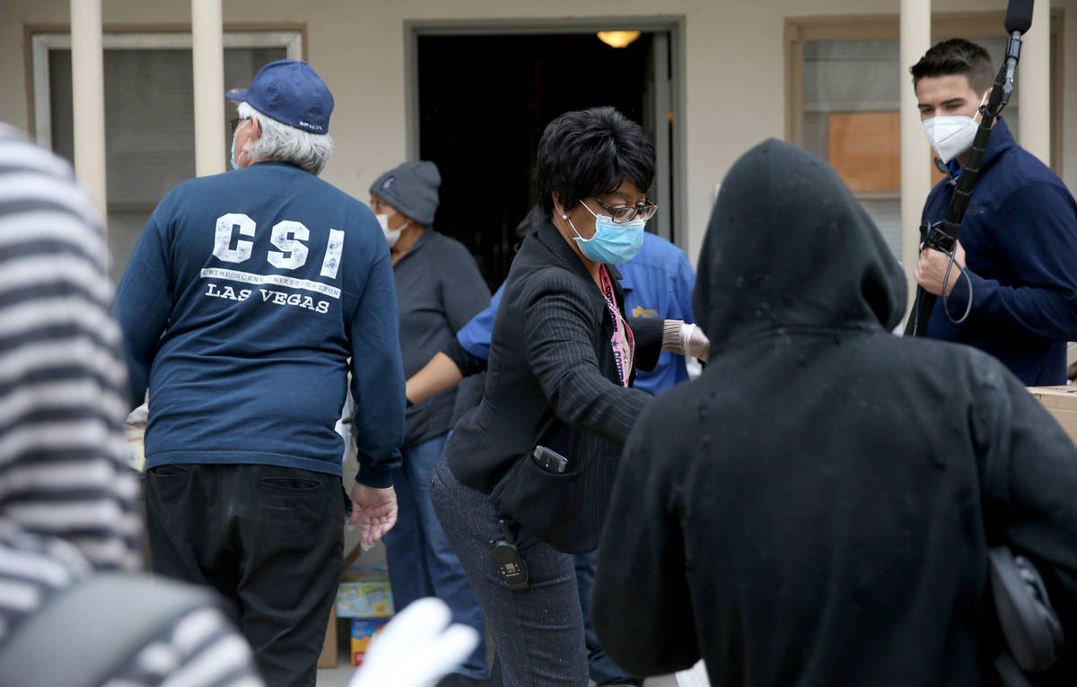 Melody Shay, property manager at Desert Plaza Apartments, center, hands out food at the downtow ...