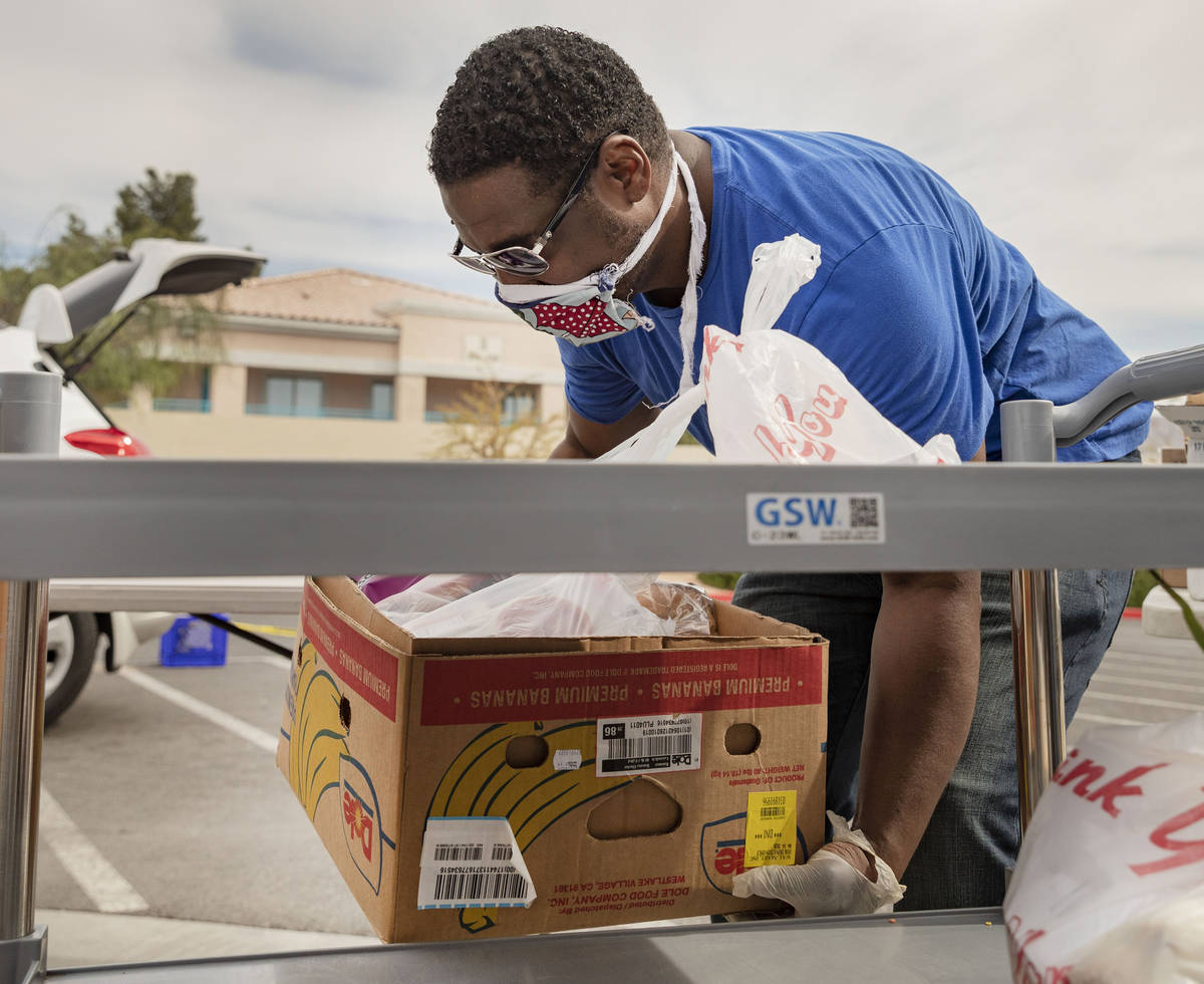 Case manager for Lutheran Social Services of Nevada Raymond Watkins loads a vehicle with an eme ...