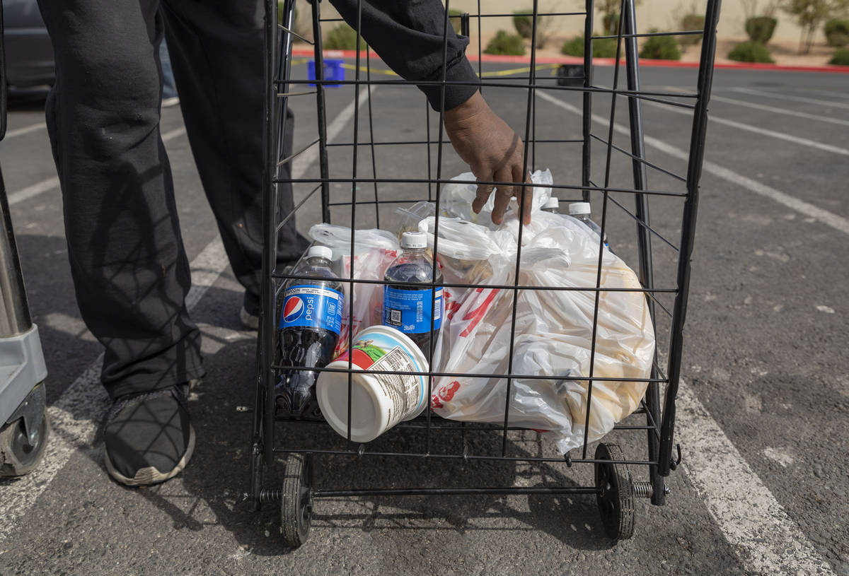 An individual loads a cart with an emergency food kit at Lutheran Social Services of Nevada, in ...
