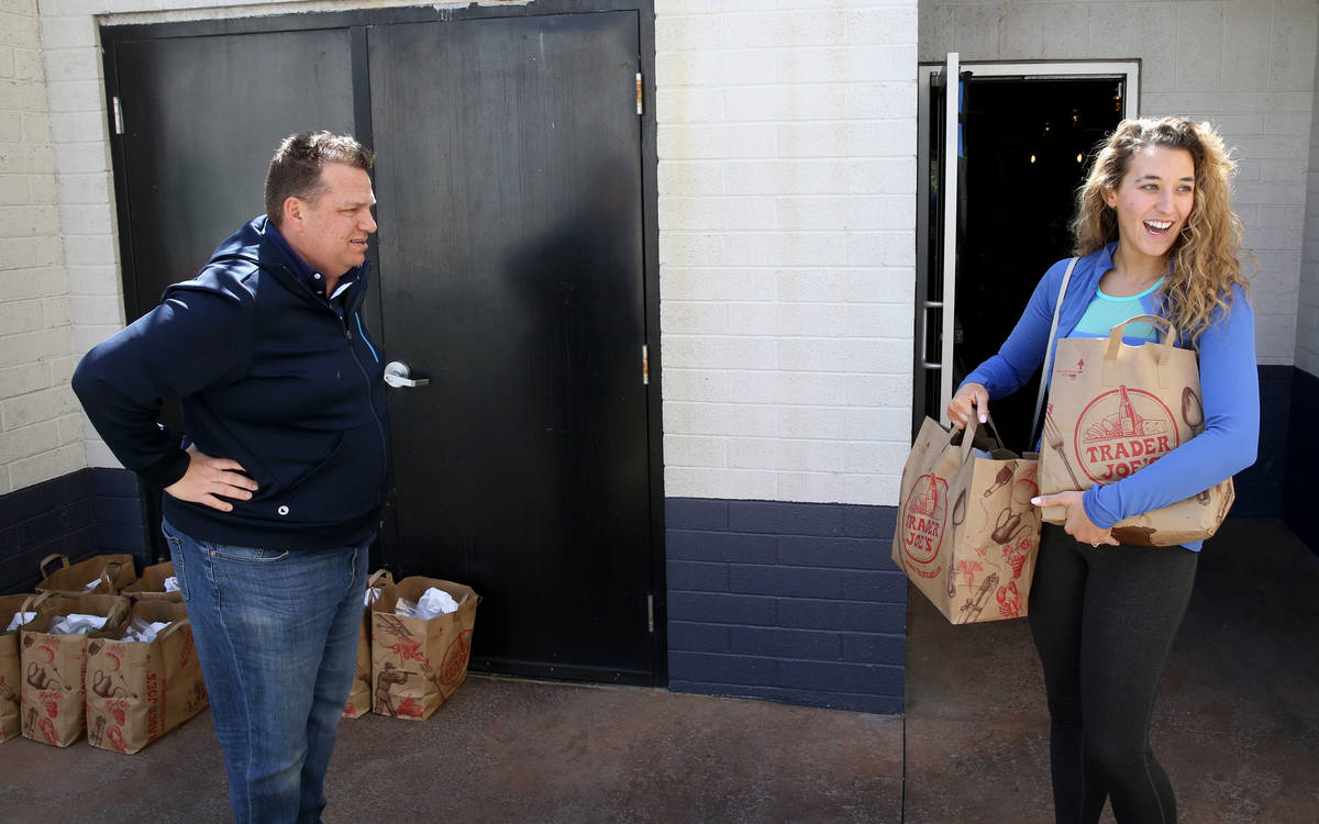 Laid off Carson Kitchen bartender Sarah Drummer receives food packages at a safe distance from ...