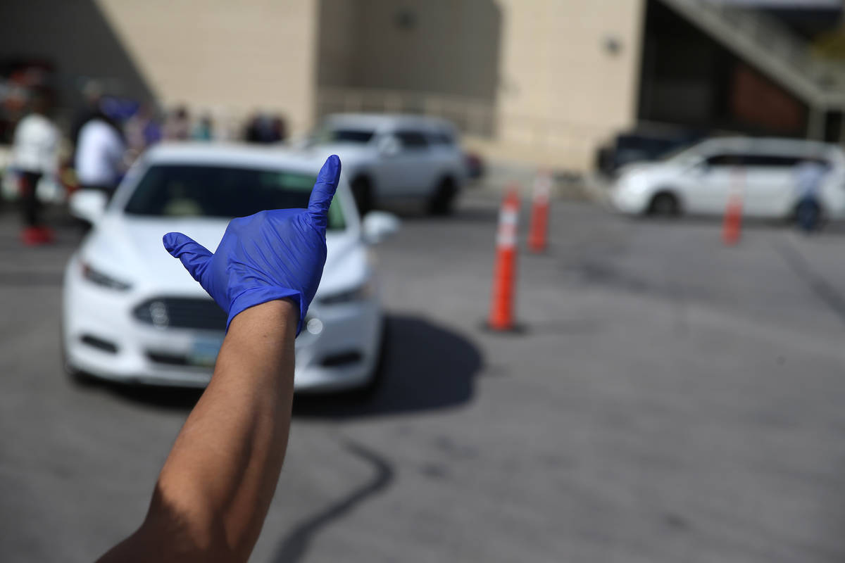 Food and beverage manager Anthony Tugaoen gestures at team members waiting in line to receive f ...