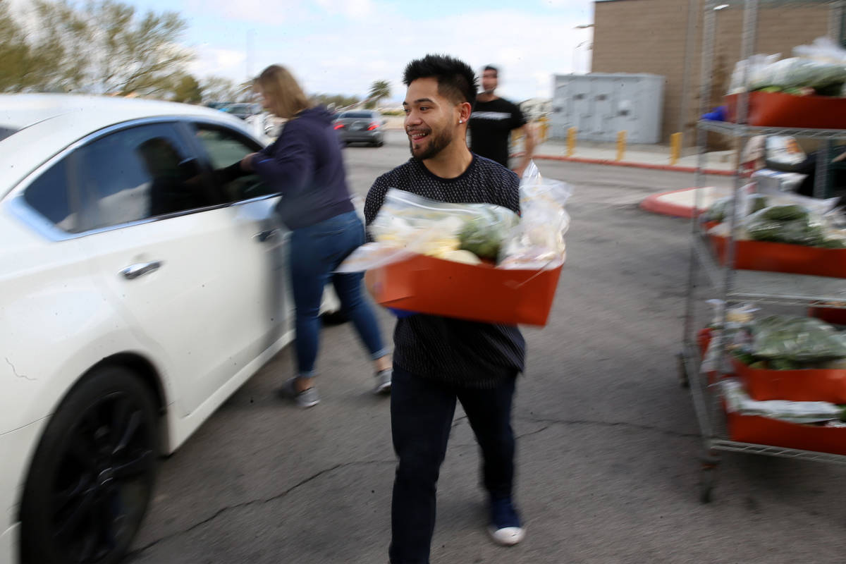 Food and beverage manager Anthony Tugaoen delivers food to a team member's car at the M Resort ...