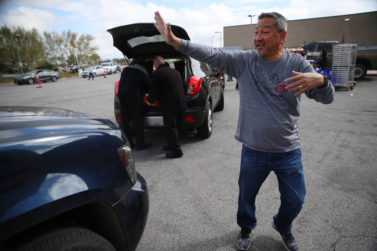 Executive director of player services Luke McEwin directs team members picking up free food at ...