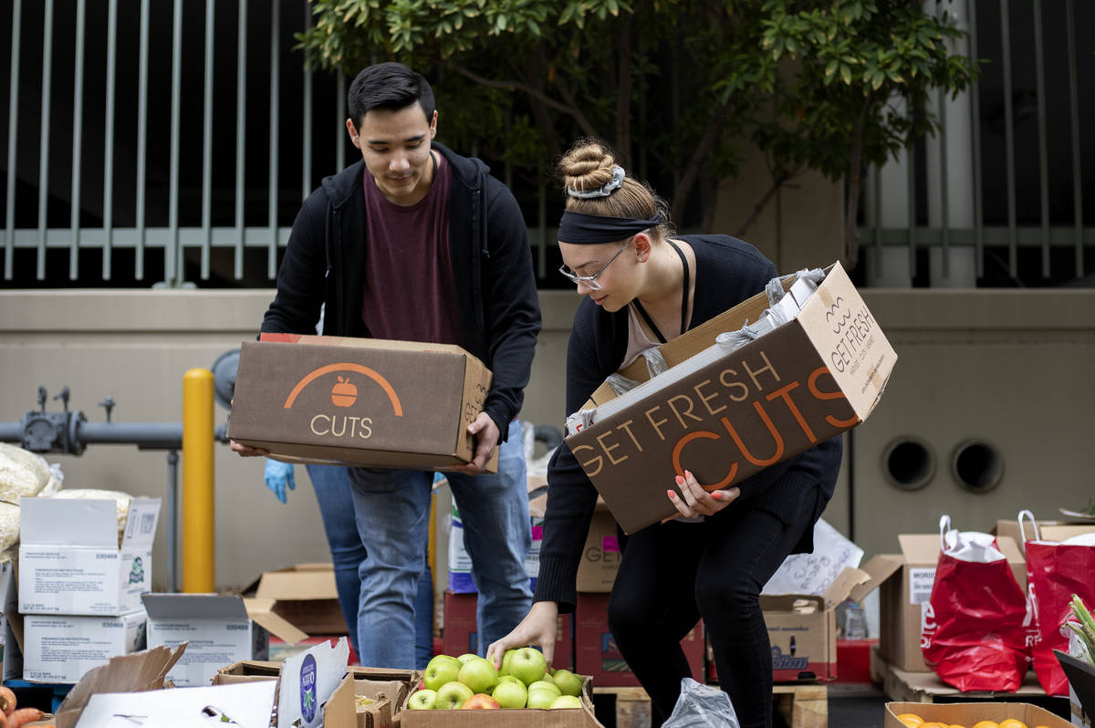 Chris Hernandez, left, and Ashlyn Haman, right, pick out produce at a food donation outside the ...