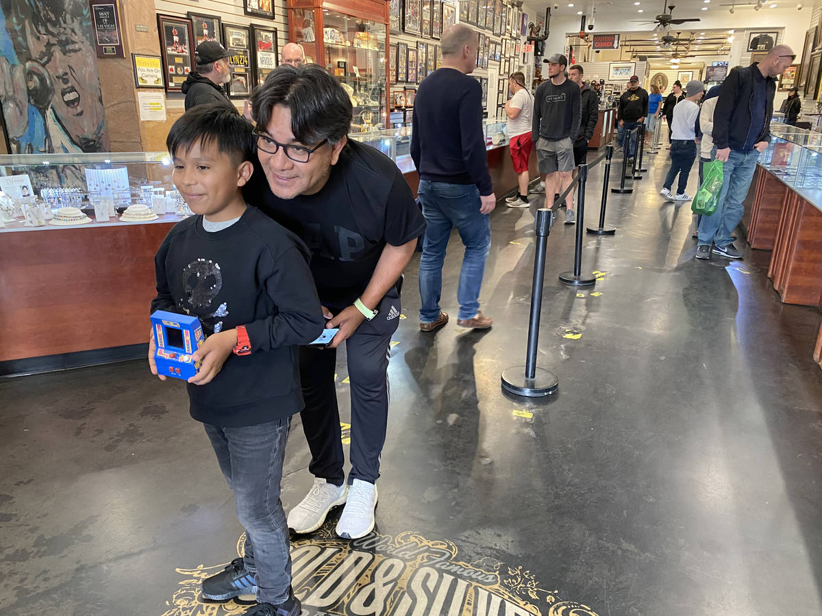 Salvador Enriquez takes a photo with his son Matias, 10, at Gold & Silver Pawn Shop in Las ...