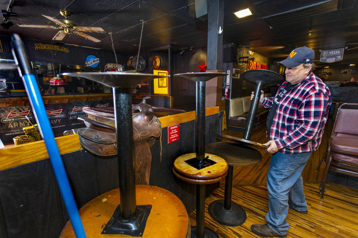 Saddle 'N' Spurs Saloon owner Bobby Kingston stacks tables in his bar, closing for the next 30 ...