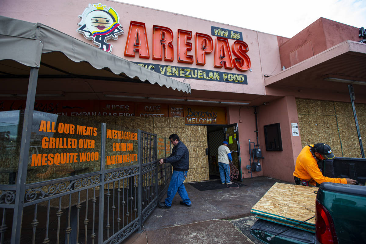 Felix Arellano, owner of Viva Las Arepas, locks the gate to an outdoor eating area as his resta ...