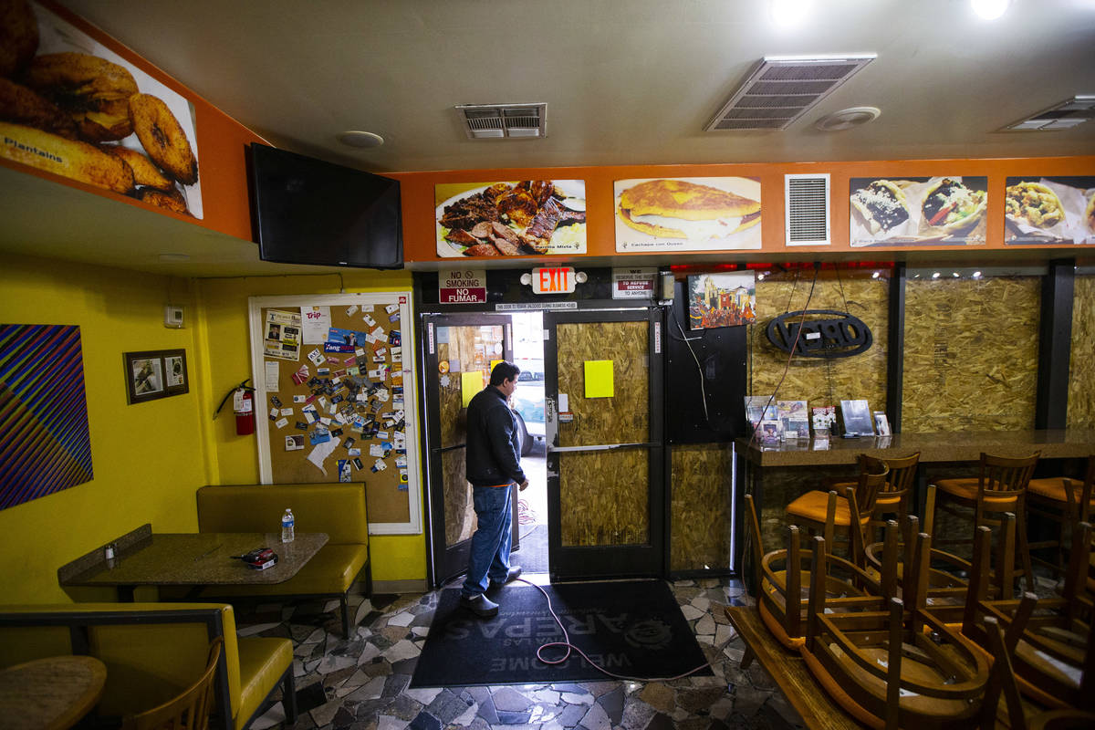 Felix Arellano, owner of Viva Las Arepas, walks through his restaurant as it gets boarded up in ...