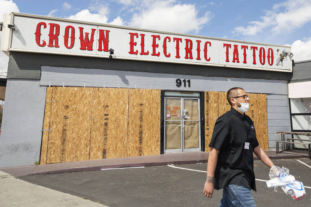 Surgio Aguirre of North Las Vegas walks by the recently boarded Crown Electric Tattoo Co. locat ...