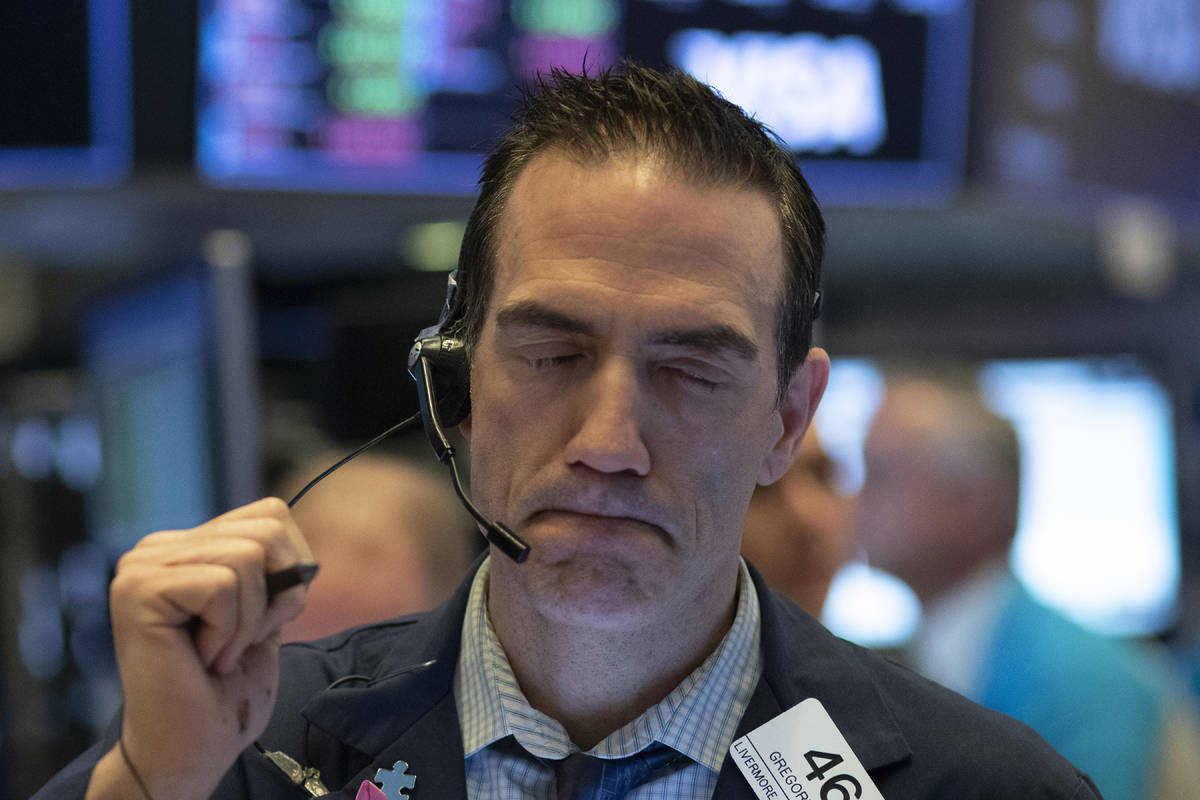 In a Wednesday, March 18, 2020, file photo, trader Gregory Rowe works at the New York Stock Exc ...