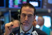 In a Wednesday, March 18, 2020, file photo, trader Gregory Rowe works at the New York Stock Exc ...