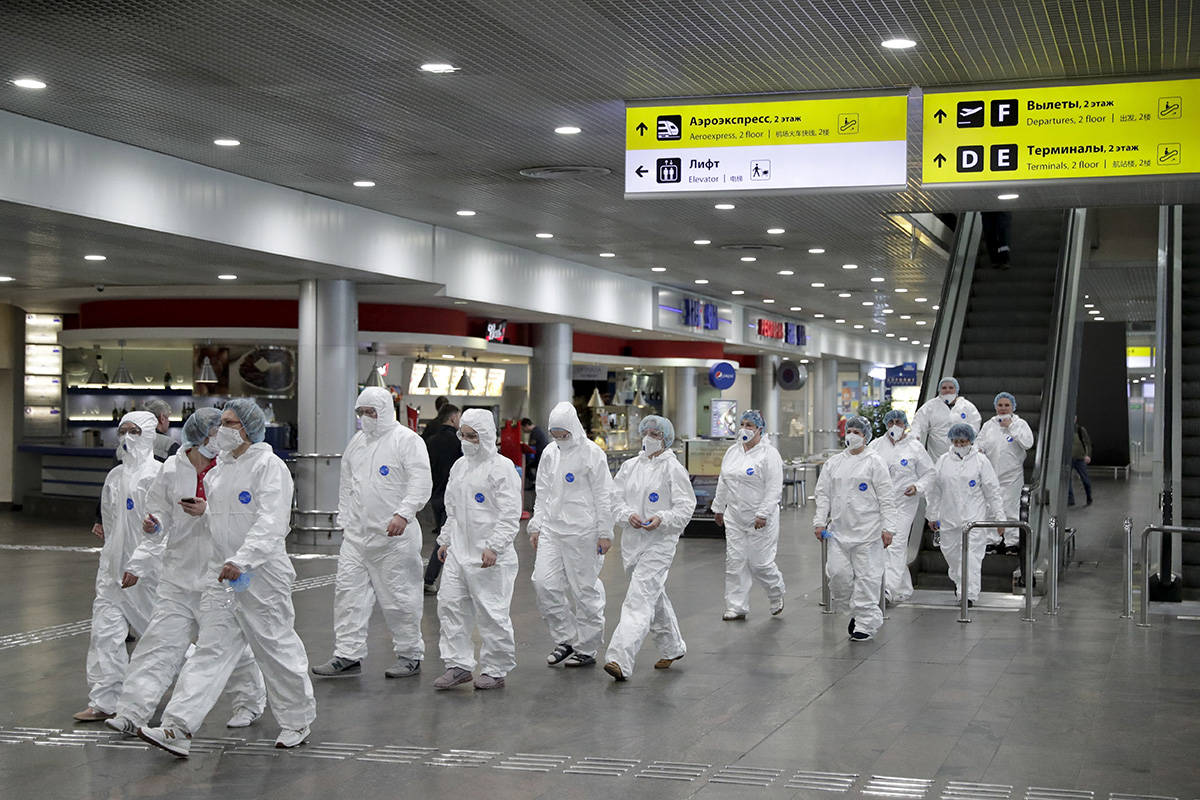 Russian medical experts walk to start their shift to check passengers arriving from foreign cou ...