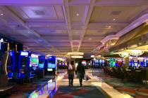 A couple wanders through the gaming area within the Bellagio as MGM shuts down casino operation ...