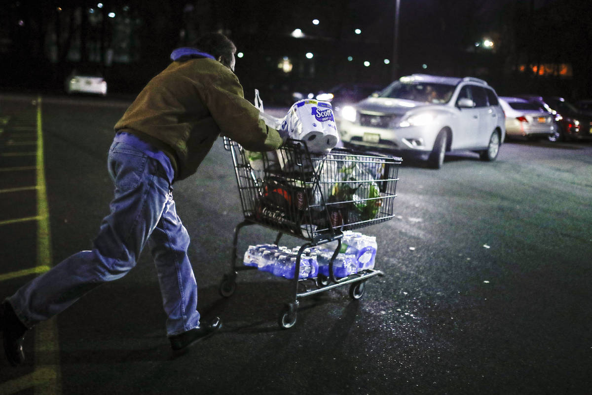Customer Harry Westhoff, 71, runs his groceries back to his car after shopping at a Stop & ...
