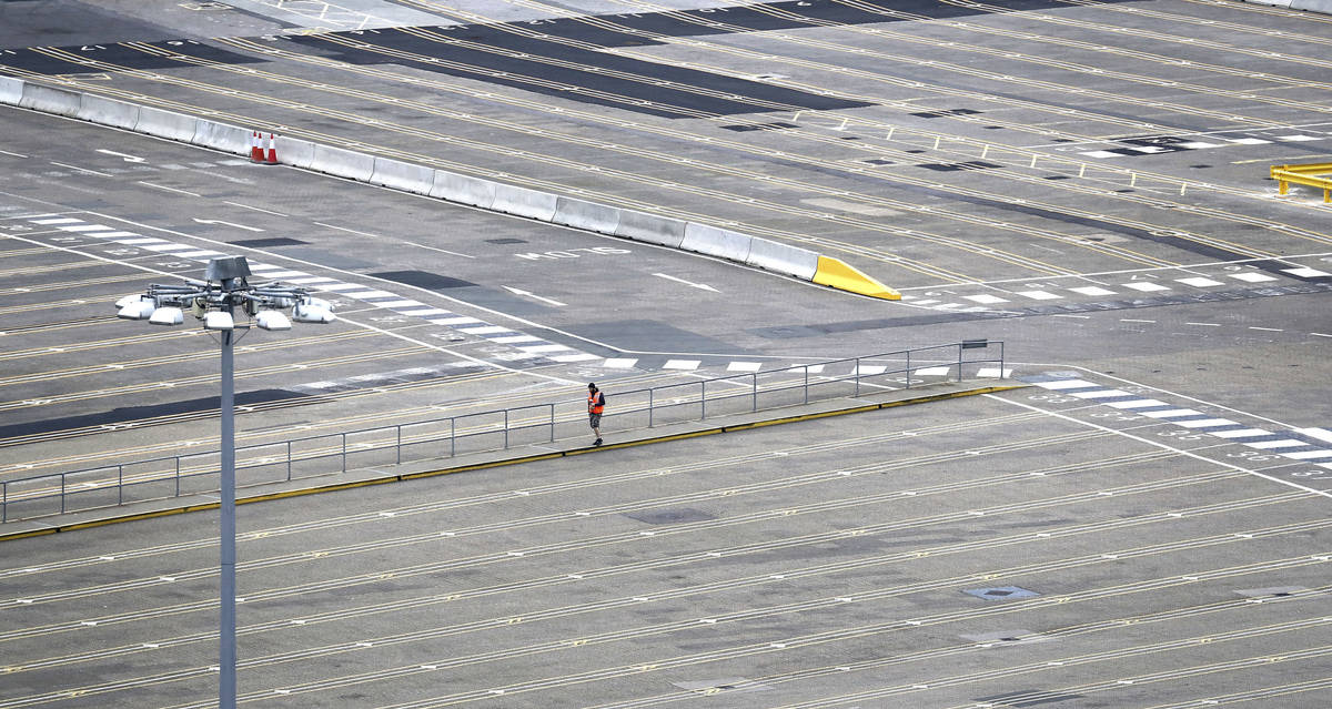 A man walks through empty passenger lanes at the Port of Dover, south east England, Friday Marc ...