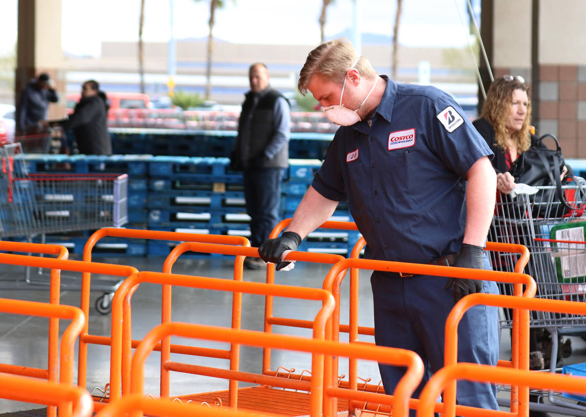 Costco employee, JD Jacobs, disinfects flat carts on Friday, March 20, 2020, in Henderson. (Biz ...