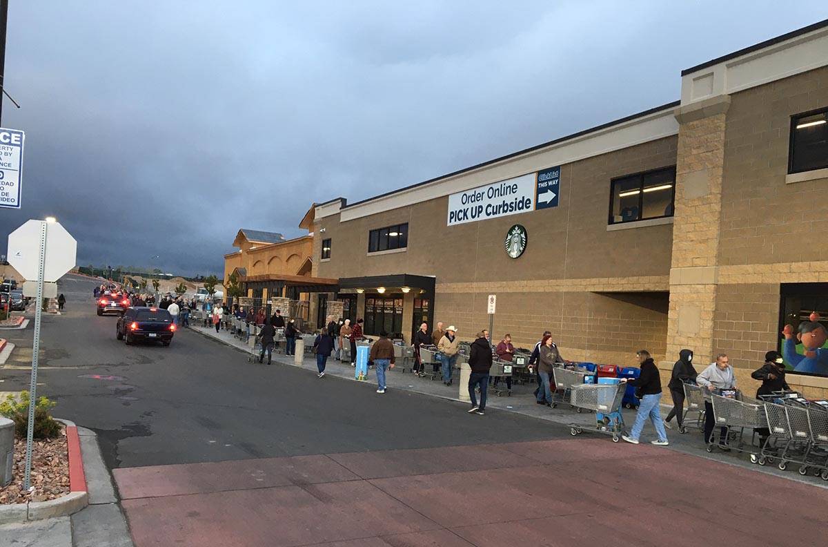 Dozens of shoppers line up at Smith's Marketplace on Skye Canyon Park Drive before 7 a.m. Frida ...