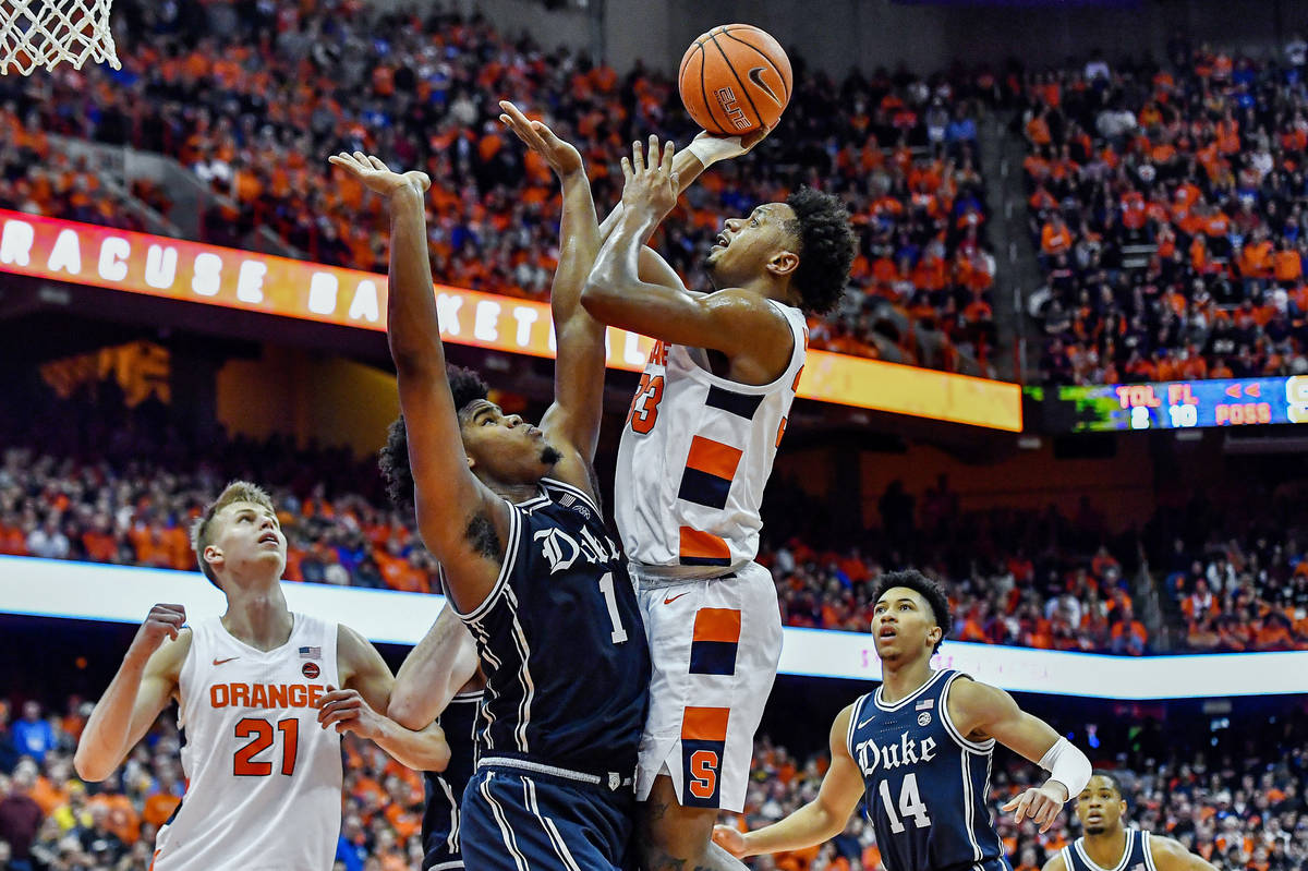 FILE - In this Feb. 1, 2020, file photo, Syracuse forward Elijah Hughes, right, shoots over Duk ...