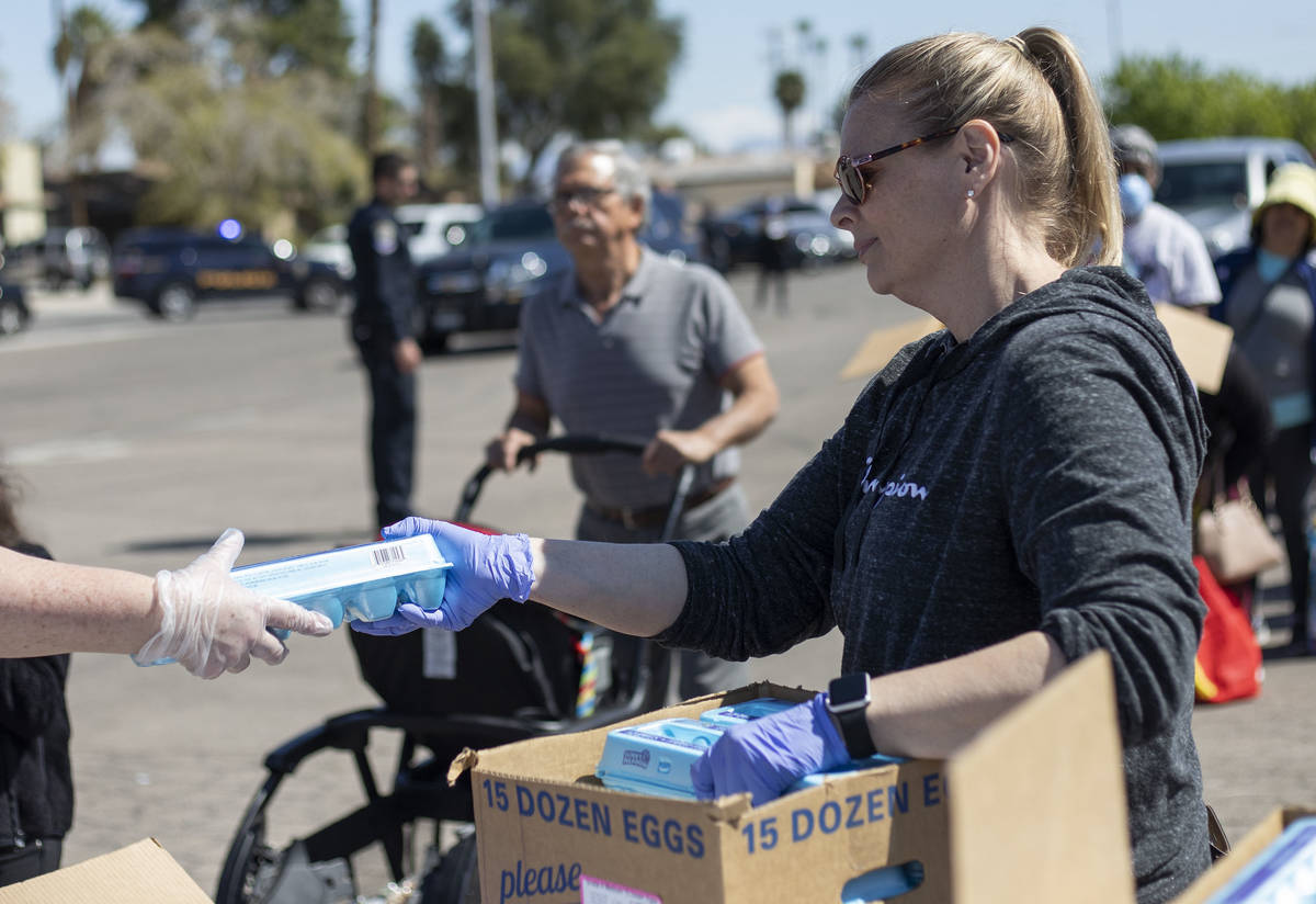 Angie Doyle, community manager at The Cosmopolitan, hands out eggs as a volunteer with The Just ...