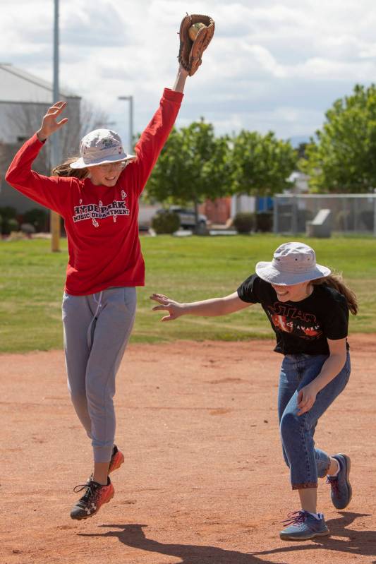 Charlotte Gillette, left, catches the ball as Rosina Gillette, right, ducks to keep from gettin ...